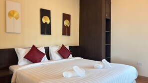 A hotel room with a large bed, two pillows, a headboard, and three wall-mounted artworks. - Palette Monsane River Kwai Resort (Kanchanaburi)