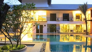 Um edifício de dois andares com piscina em primeiro plano.