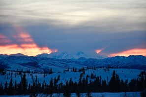 A snowy mountain landscape with a clear sky and distant mountains. - Earthsong Lodge (Healy)