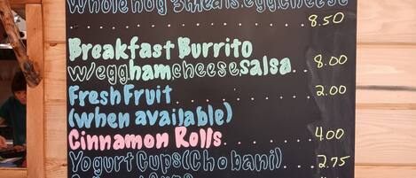 A blackboard menu with various breakfast items and prices.
