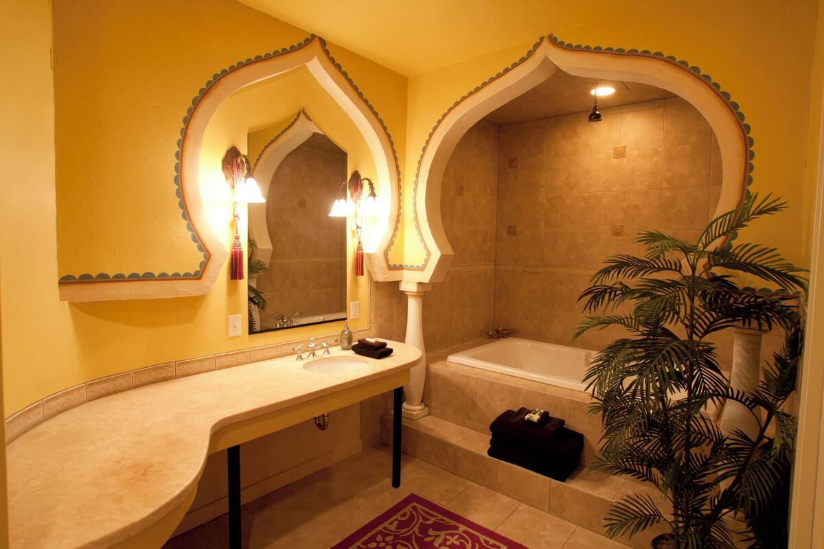 A bathroom with a sink, mirror, and bathtub.