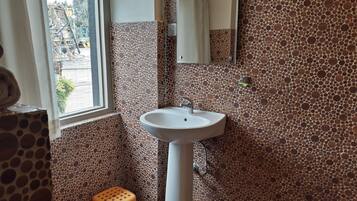 Un baño con lavamanos, espejo y paredes con diseño.