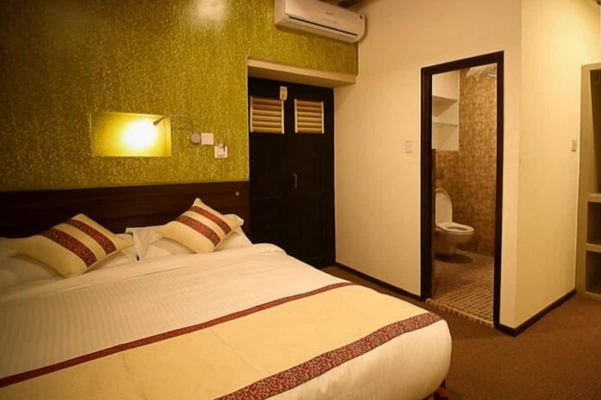 Una habitación de hotel con cama, armario y baño.