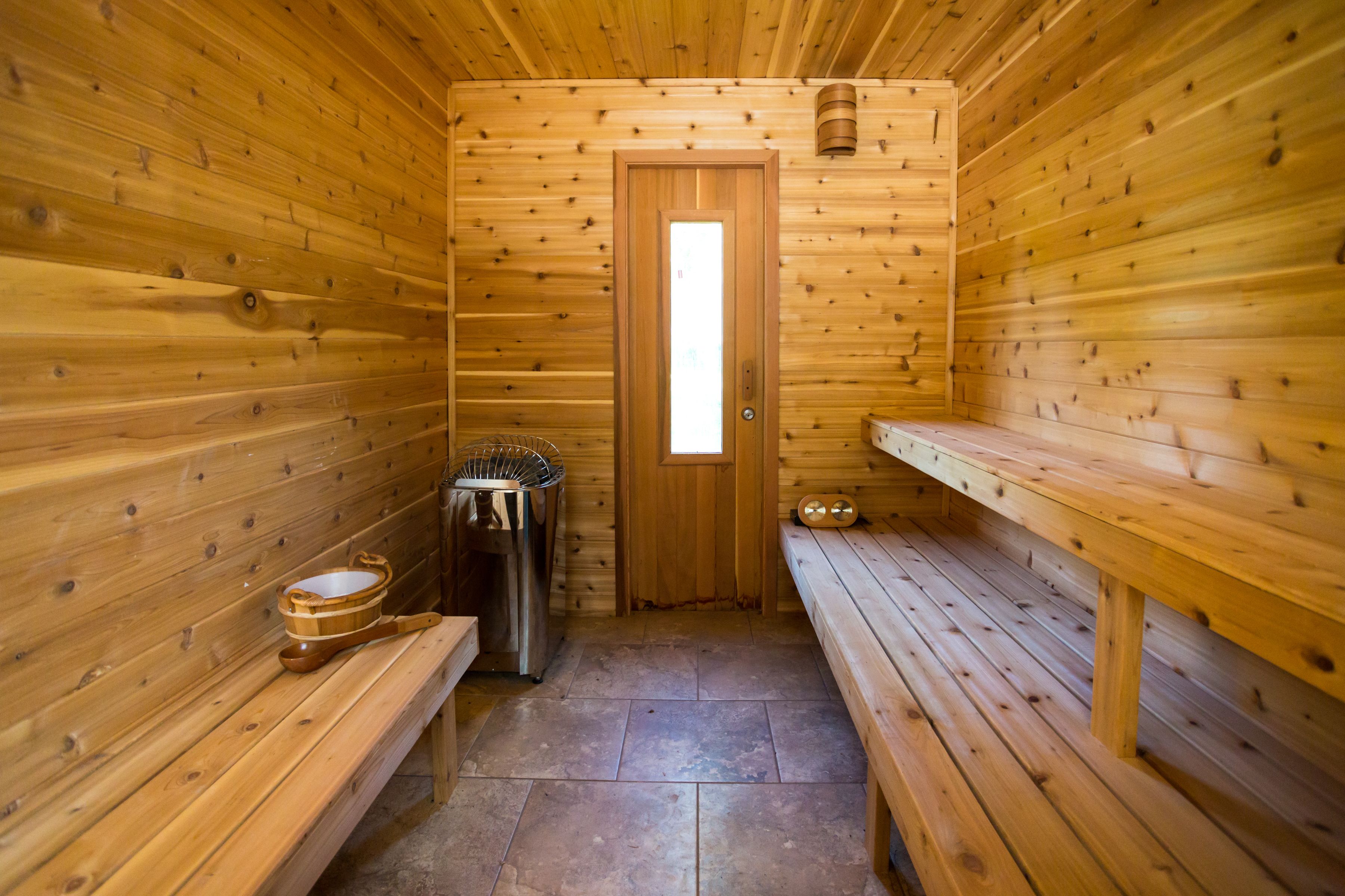 A wooden sauna with benches and a door.