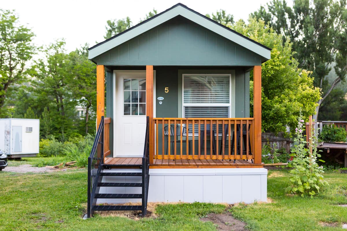 A small, single-story house with a front porch and a number '5' on the door.
