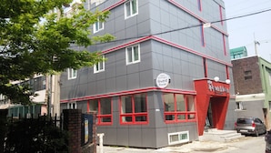 A multi-story building with a sign indicating it is a guest house.