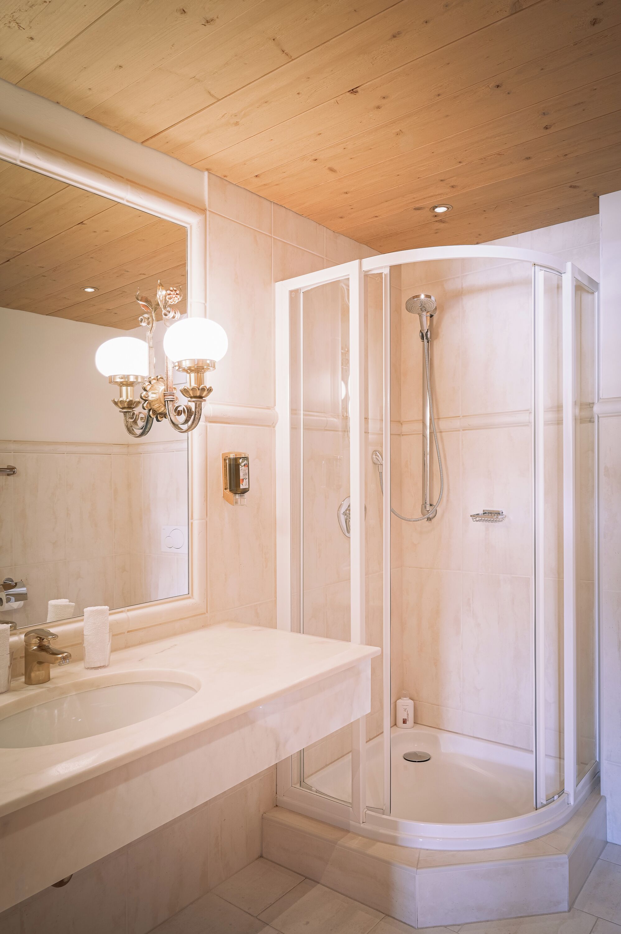 A bathroom with a curved shower, a large mirror, and a sink.