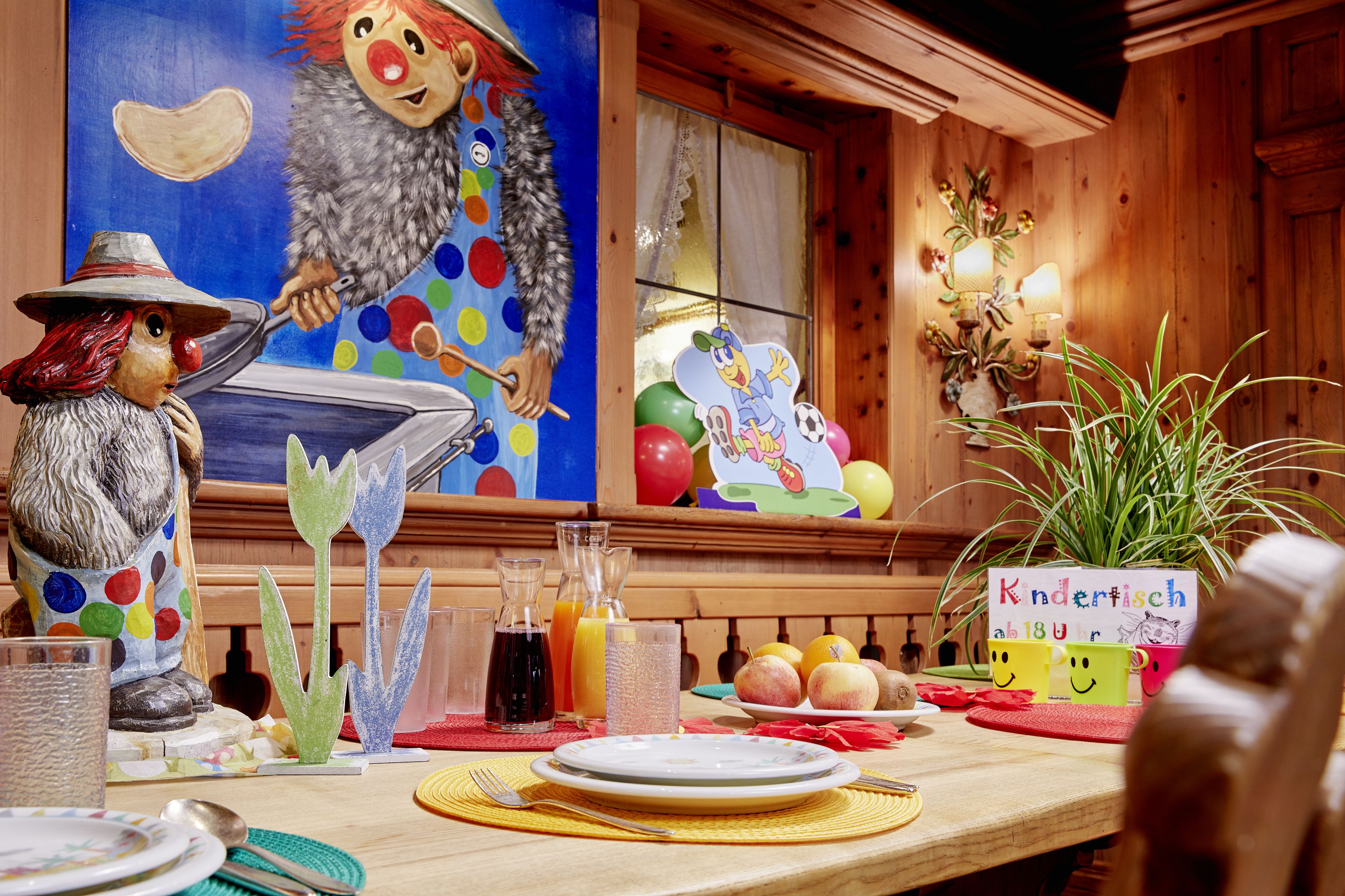 A dining table set with plates, cutlery, and a variety of drinks.