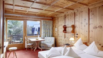 Una habitación con paneles de madera, una cama, un escritorio, una silla y una ventana.