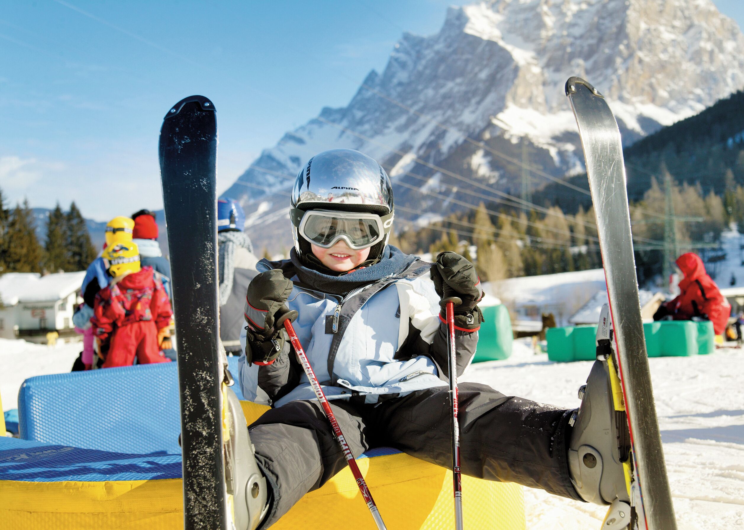Une piste de ski avec des skieurs et une montagne en arrière-plan.