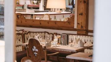 A restaurant interior with wooden furniture, hanging lamps, and a cozy ambiance.