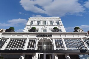 A white building with the sign "LOGIERAUS" and a large arched entrance. - Logierhaus am Denkmal (Norderney)