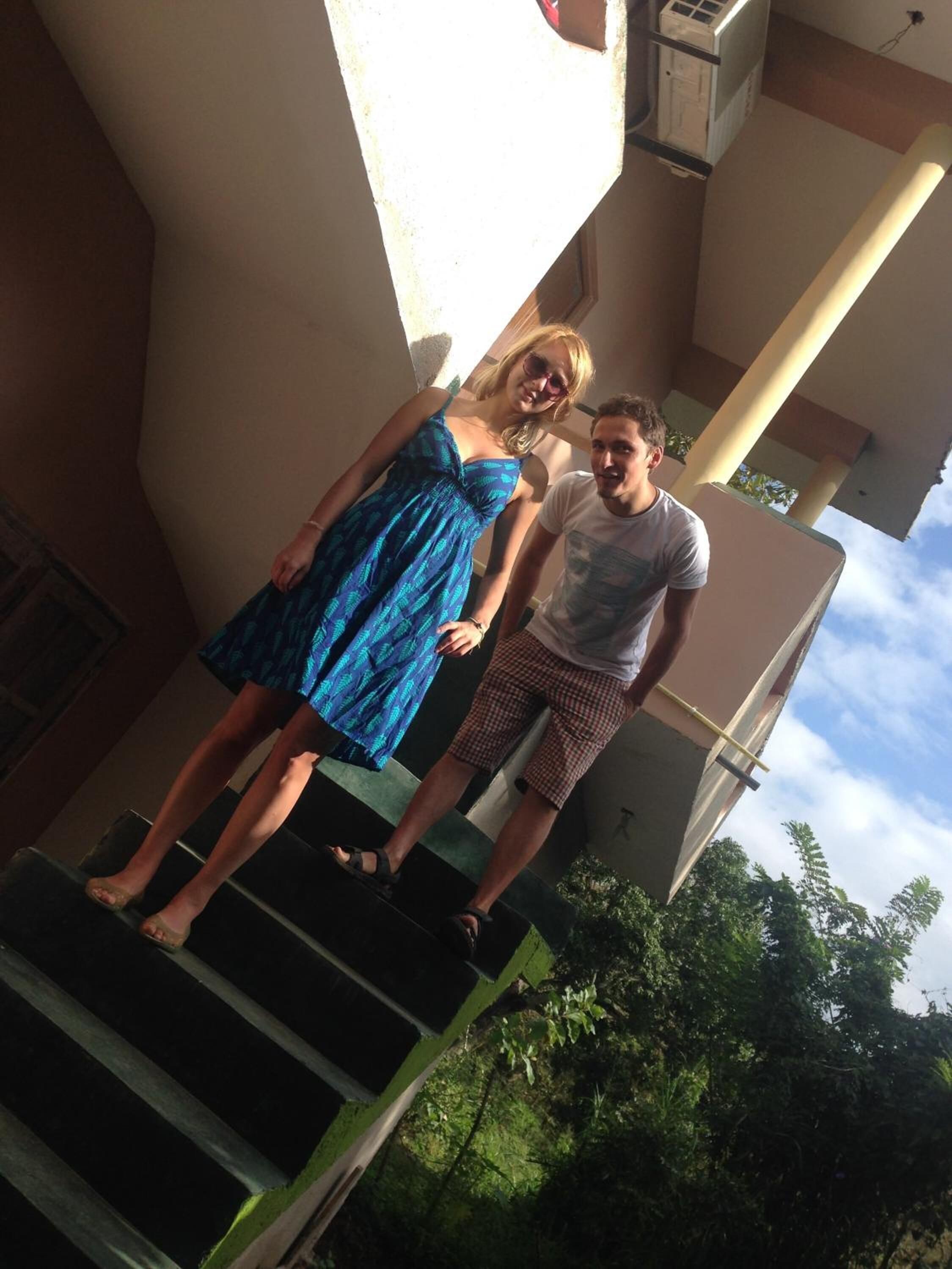 Two people standing on outdoor stairs with a building in the background.