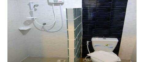 Un baño con inodoro, ducha y pared con azulejos.