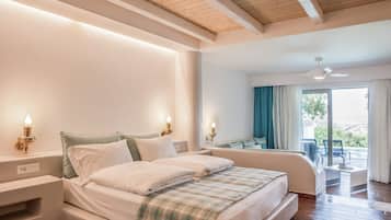 Un dormitorio con una cama grande, mesitas de noche, un ventilador de techo y vistas al exterior.
