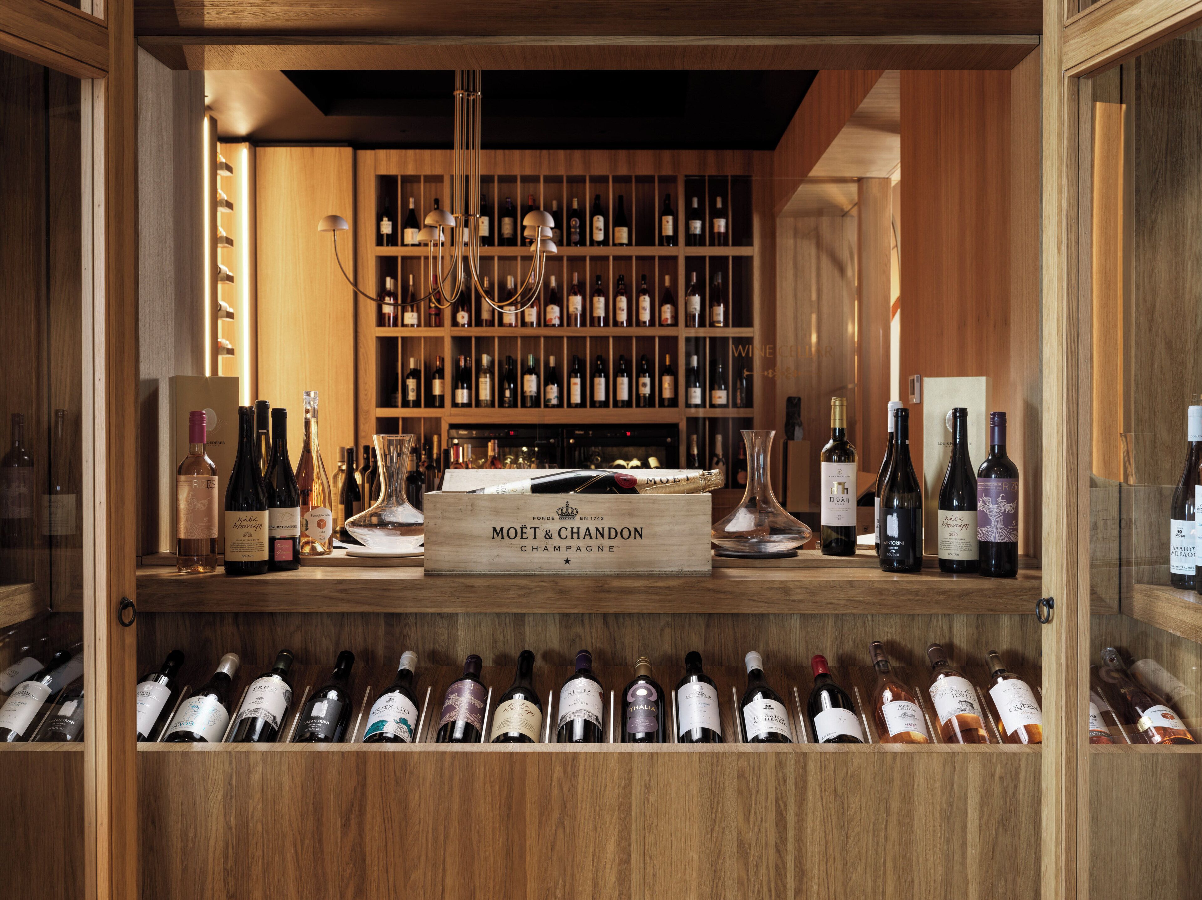 Une cave à vin avec des étagères en bois et une variété de bouteilles de vin.