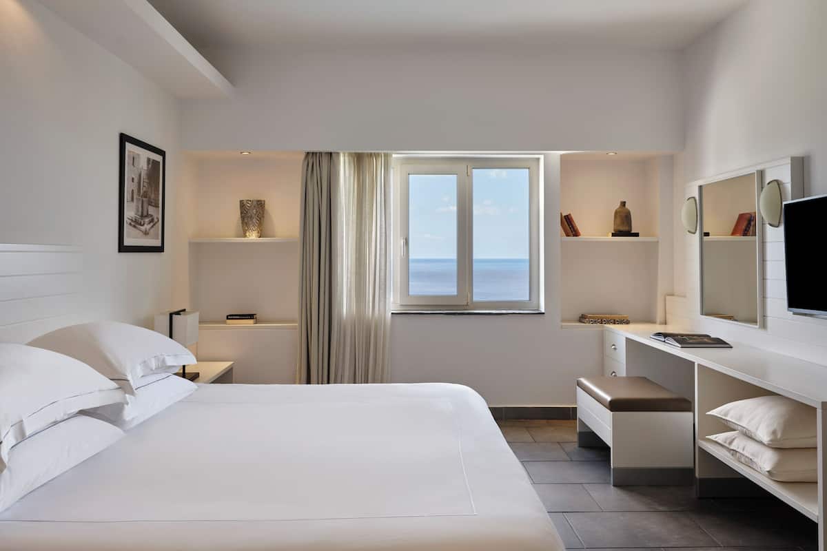 Suite, vista al mar (Sharing Pool) | Caja de seguridad en la habitación, escritorio y cortinas blackout