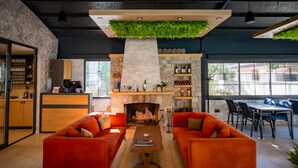 Un espace de vie moderne avec deux canapés orange, une table basse en bois et une cheminée en pierre.