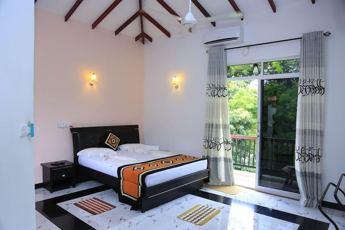 A bedroom with a bed, nightstands, a window with curtains, and a balcony.