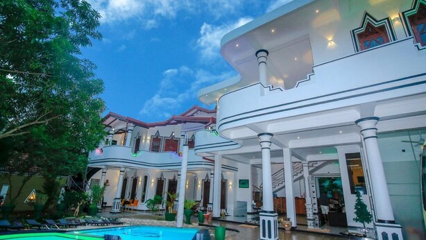 A luxurious hotel with a swimming pool, multiple balconies, and a grand entrance. - Hotel River Front (Thissamaharama)