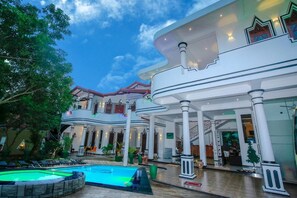 A luxurious hotel with a swimming pool, multiple balconies, and a grand entrance. - Hotel River Front (Thissamaharama)