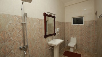 Une salle de bain avec une douche, un lavabo et des toilettes.