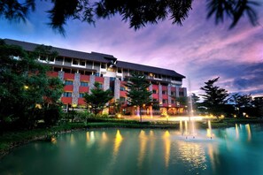 A multi-story hotel with a pool and fountain, surrounded by greenery. - The Charm Boutique Resort & Hotel (Khon Kaen)