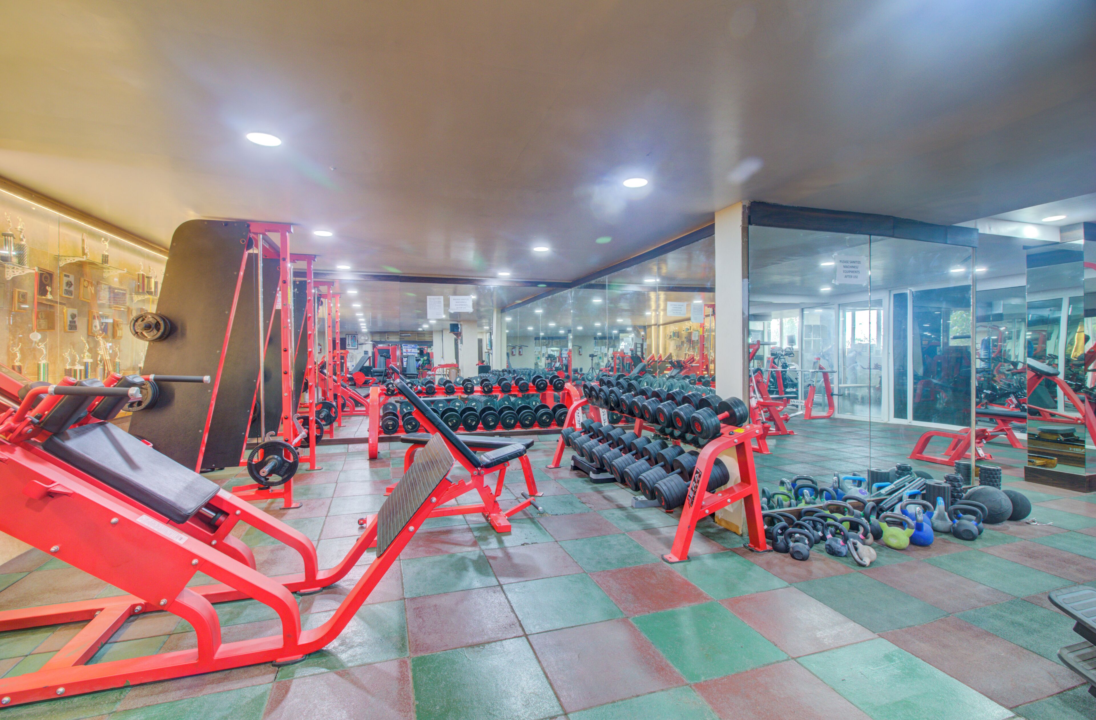 A gym with various exercise equipment, including treadmills, weight machines, and free weights.