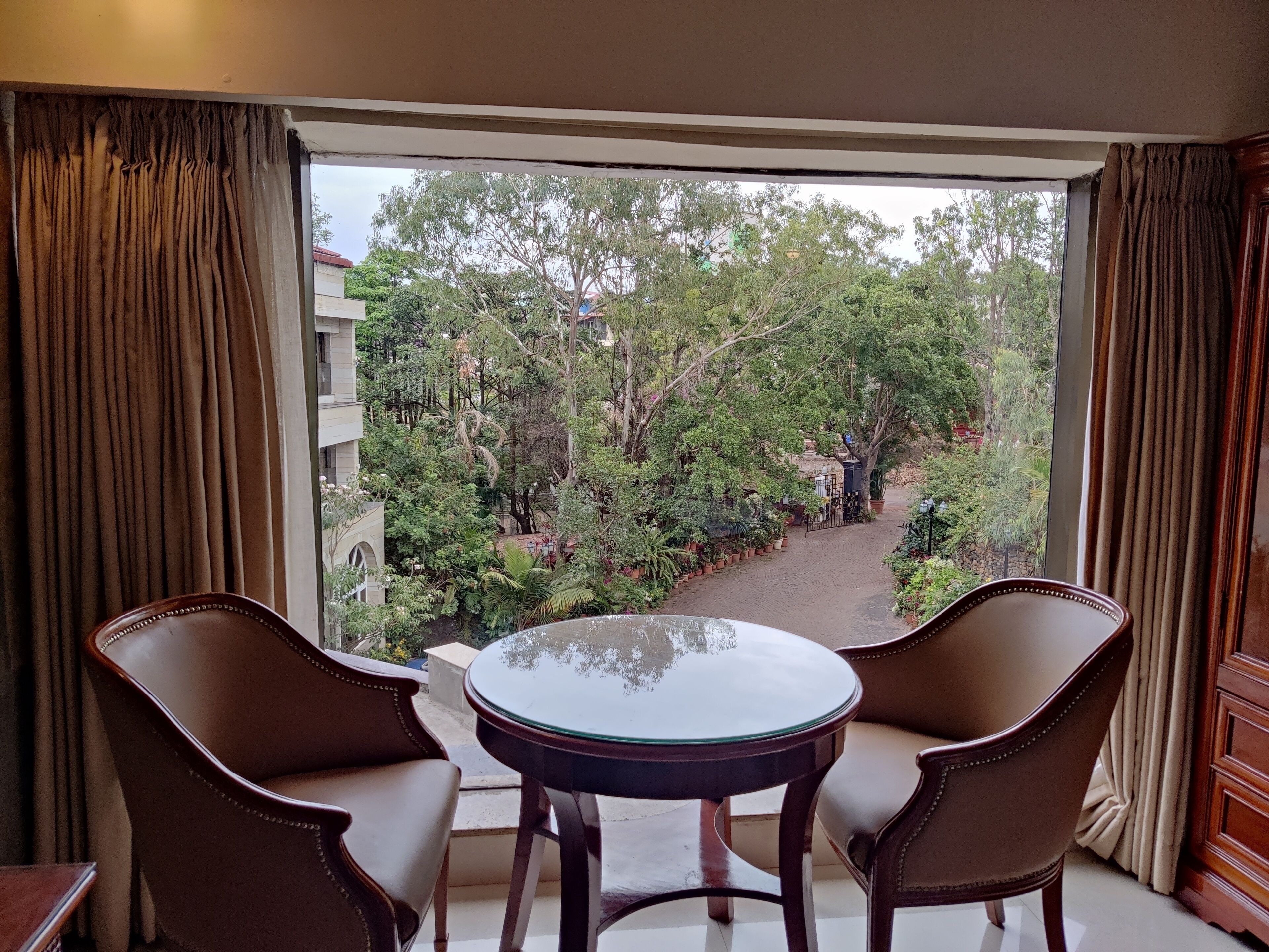 A room with a balcony, two chairs, and a small table.
