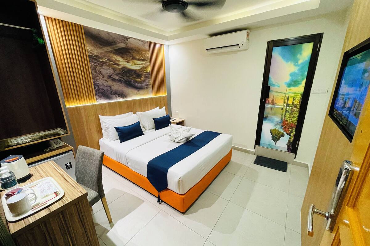 Una camera d'albergo con un letto, una scrivania, un condizionatore e un quadro appeso al muro.