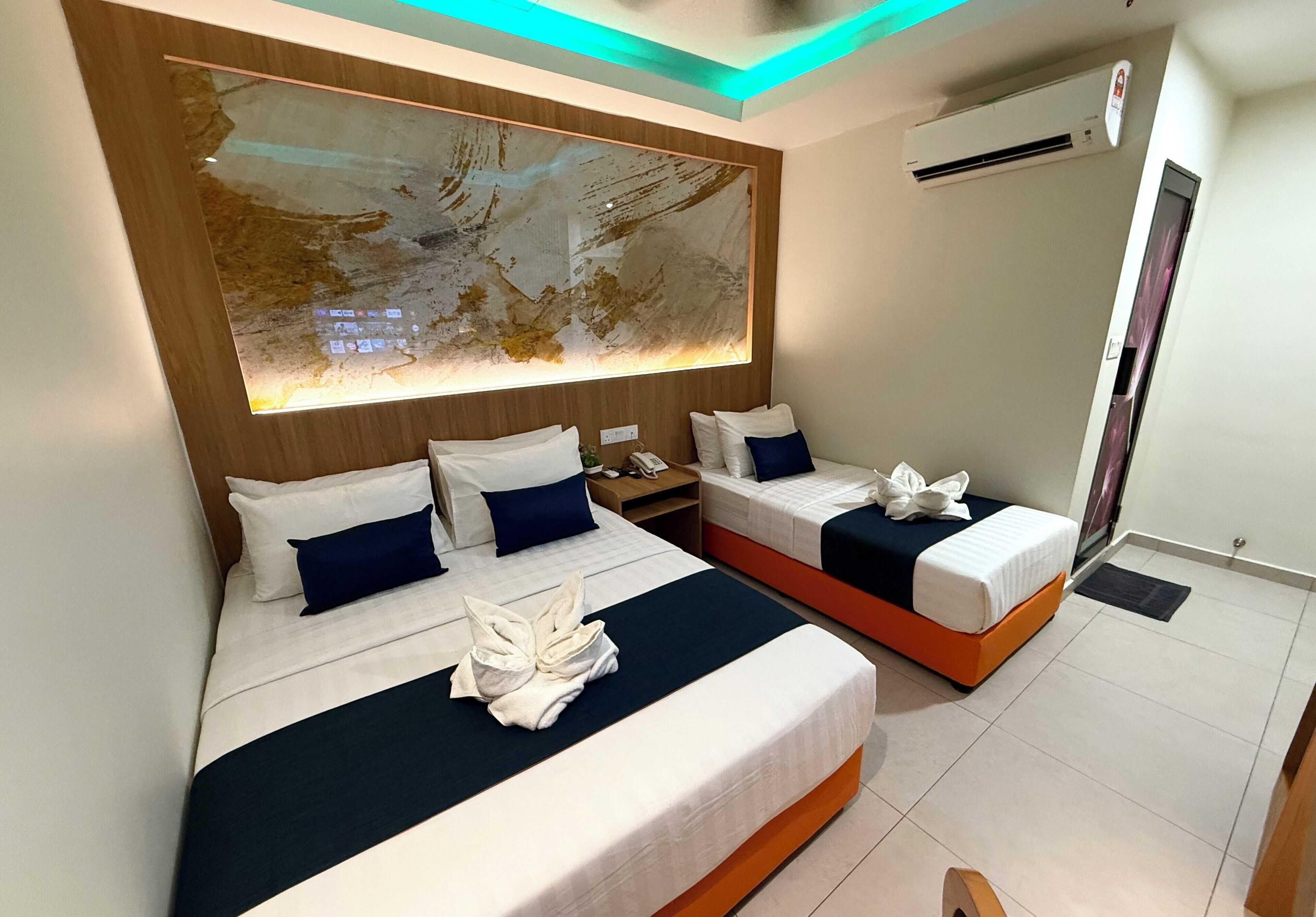 A hotel room with two beds, a large abstract painting on the wall, and a modern ceiling design.
