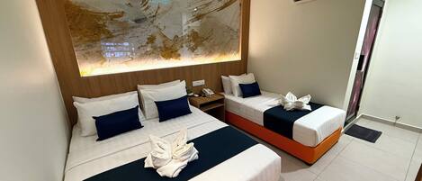 A hotel room with two beds, a large abstract painting on the wall, and a modern ceiling design.