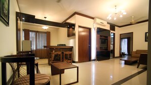 Un salón amplio con una mesa de centro de madera, un sofá y un comedor con sillas.