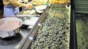 Montaje de bufé con alimentos y una estación de cocina.