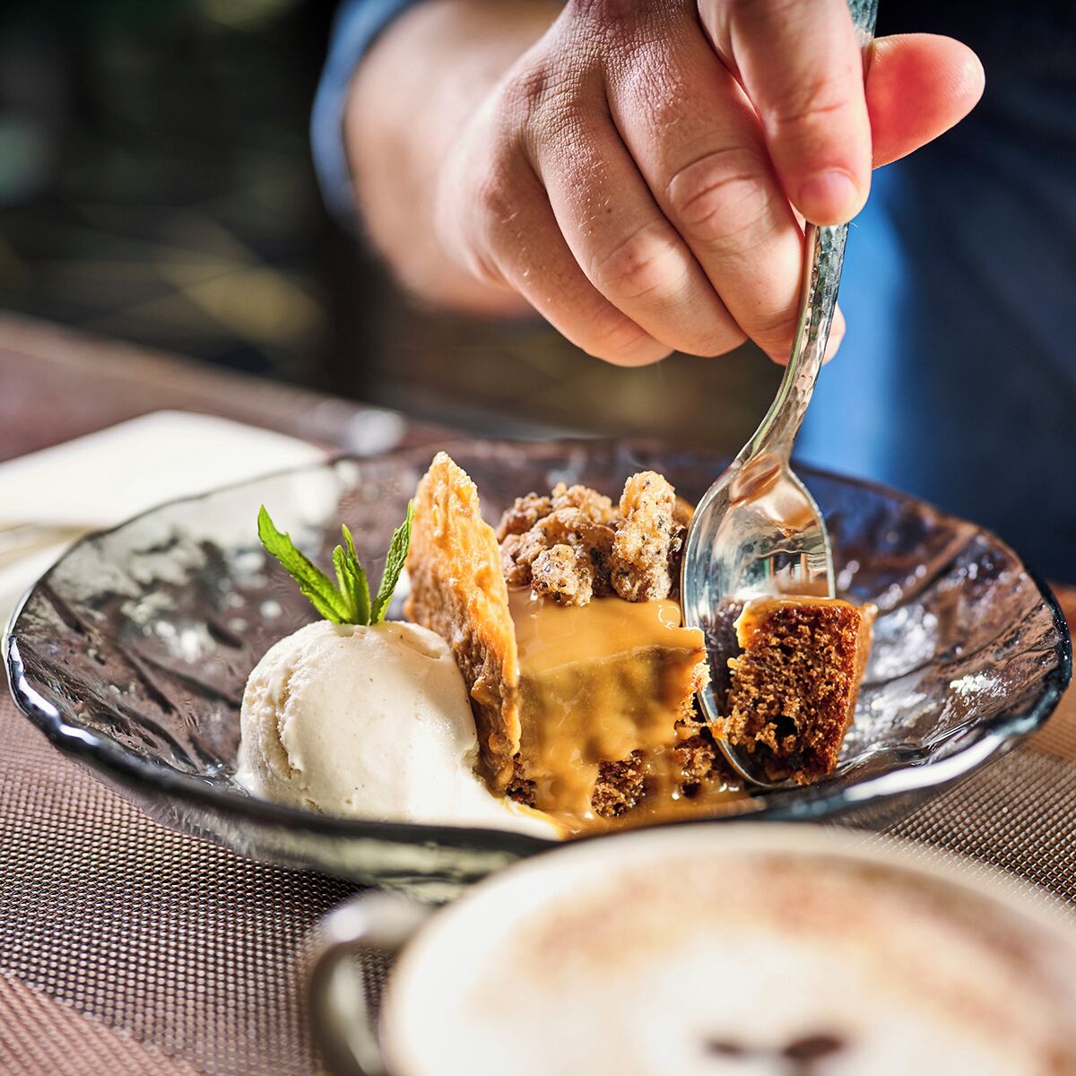 Ein Dessertteller mit Eis, Karamellsauce und einem Kuchenstück.
