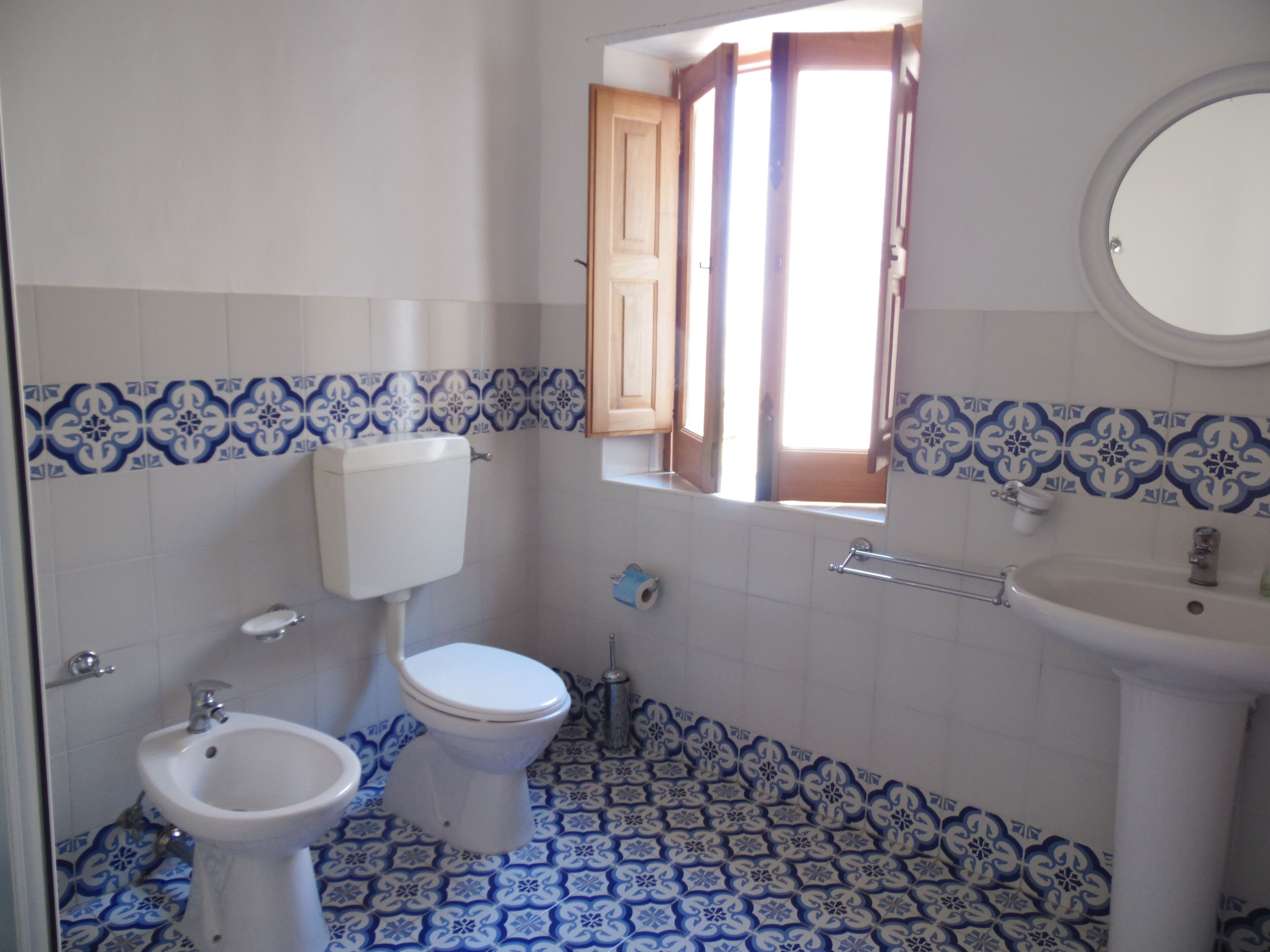 Et badeværelse med toilet, bidet og håndvask.