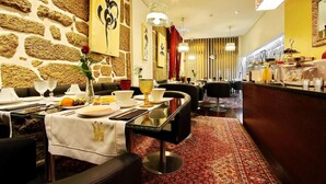 A restaurant with stone walls, a patterned carpet, and a buffet area. - Hotel Mestre de Avis (Guimarães)