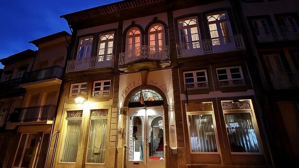 A hotel with a classic facade, multiple balconies, and a prominent entrance with a sign. - Hotel Mestre de Avis (Guimarães)