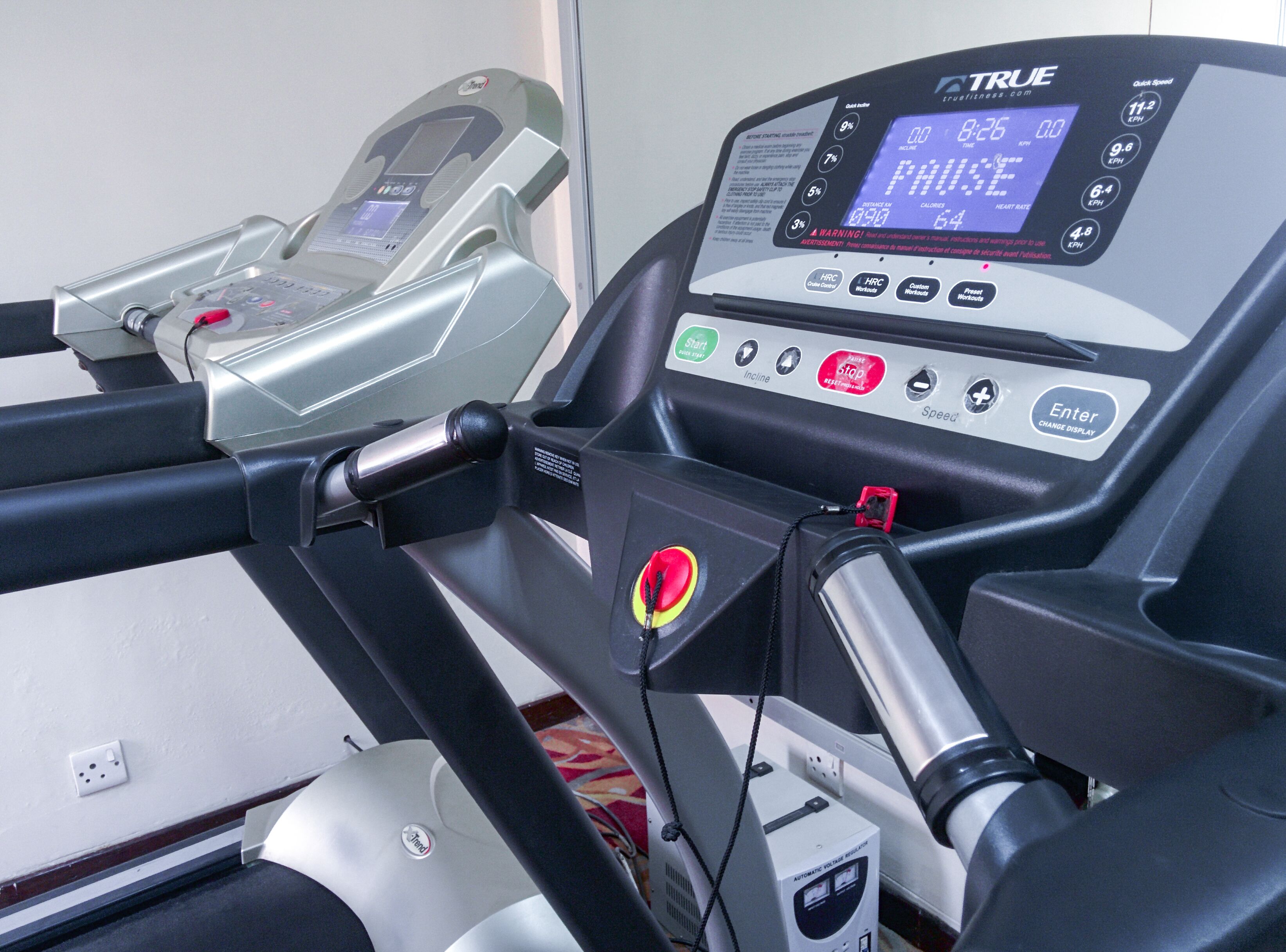 A treadmill with a digital display, control panel, and safety features.