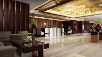 Una hall moderna con reception, area salotto e illuminazione decorativa.