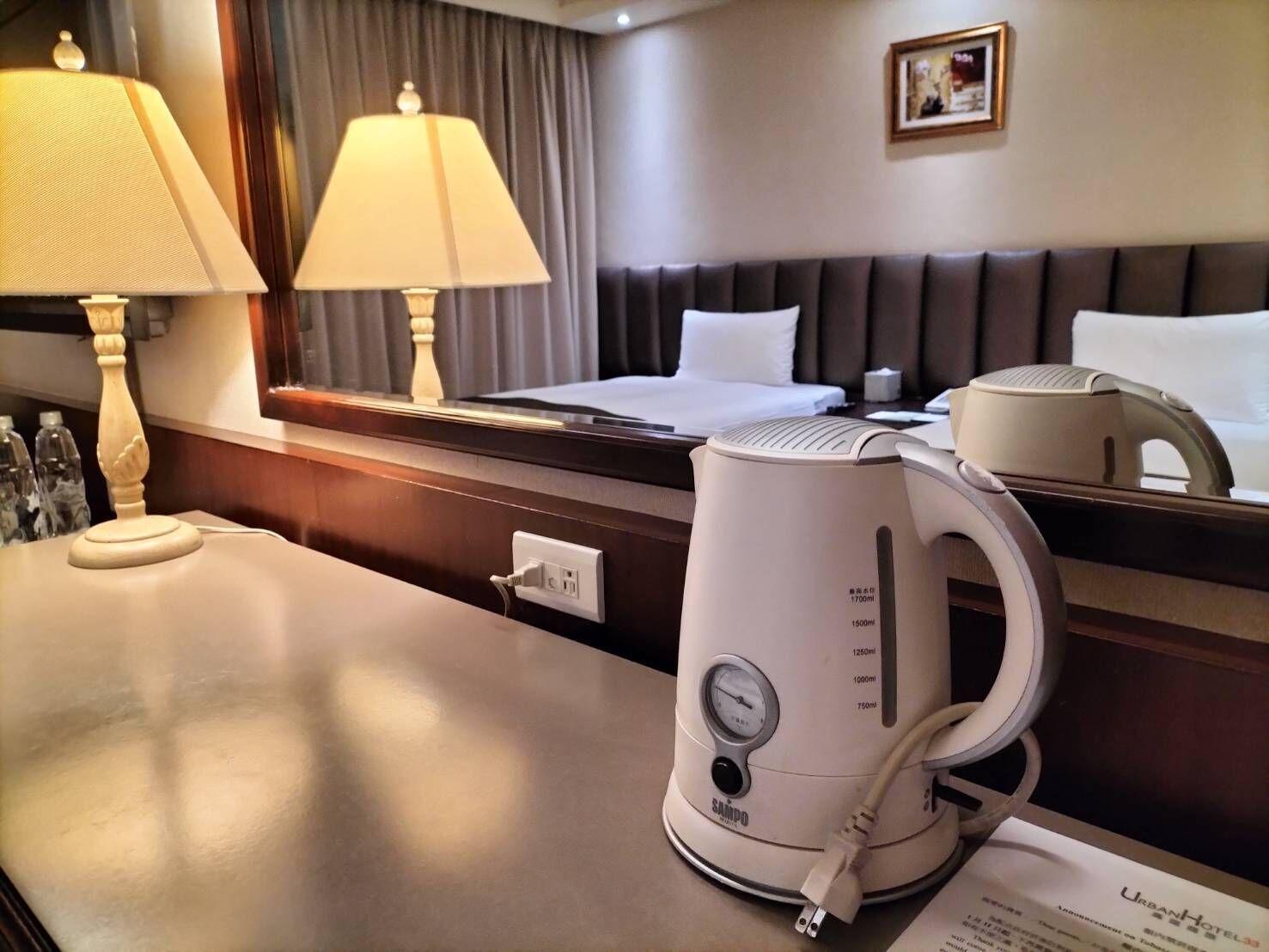Une chambre d’hôtel équipée d’un lit, de lampes de chevet, d’un mini-bar et d’une machine à café posée sur le comptoir.