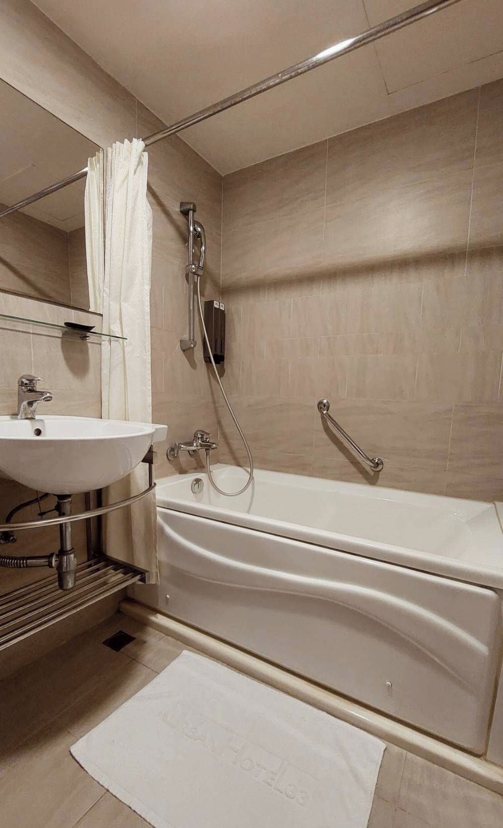 A modern bathroom with a bathtub, a sink, and a shower.