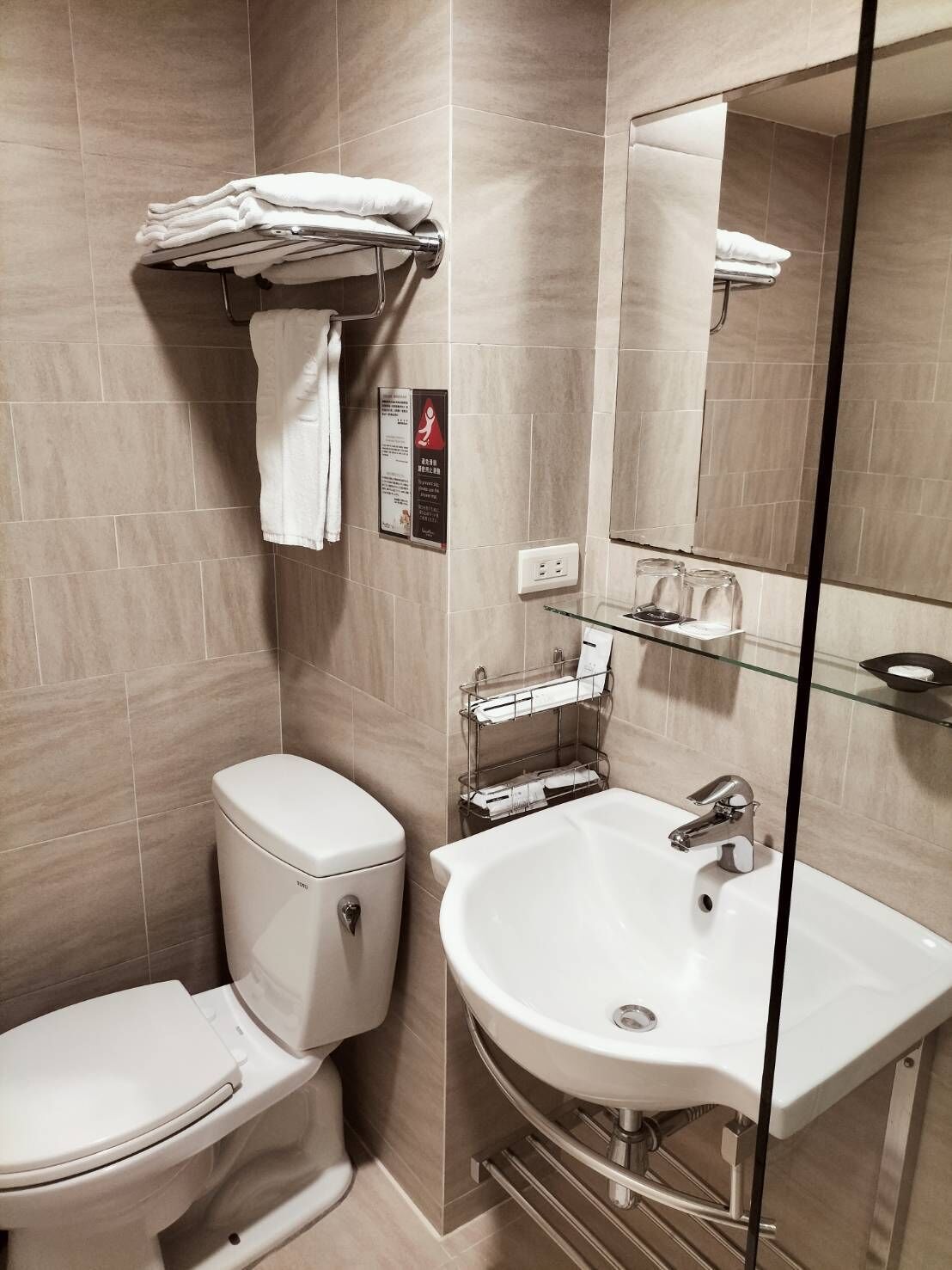 Un baño moderno con inodoro, lavabo y cabina de ducha de vidrio.