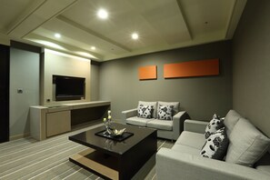 A modern living room with a flat-screen TV, a sofa, and a coffee table.