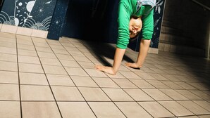 A person performing a handstand against a wall with a mural, in front of a liquor store. - Kaboom Maastricht (Maastricht)