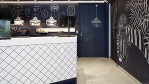 A modern reception area with a dark wall featuring decorative elements and a tiled floor. - Kaboom Maastricht (Maastricht)