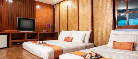 A hotel room with two beds, a television, and a window.
