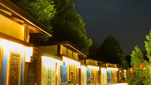 A pathway leading to a building with illuminated signage and traditional architectural elements.