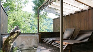 A wooden deck with a bench and a tree trunk.