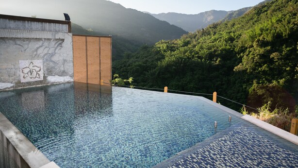 A infinity pool with a view of a mountainous landscape.